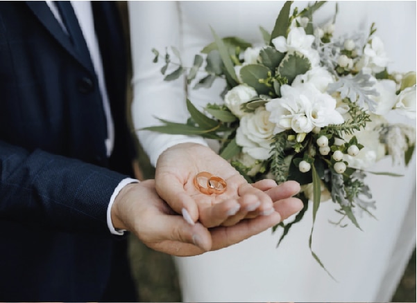 Manos de dos recién casados en el Caribe con las dos alianzas sobre las palmas de las manos